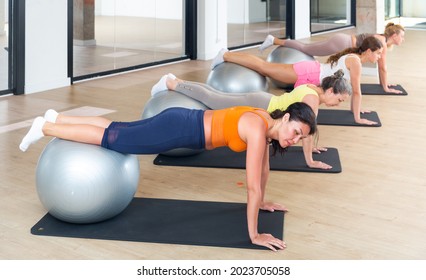 Women Doing Plank With Swiss Balls During Pilates Training