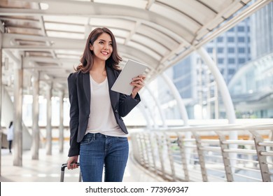 Women Are Dragging Their Luggage In A Smartphone. See Mobile Travel Maps. During The Trip To The Airport. Businesswoman Using Smart Phone Ordering Taxi On APP,Taxi Service Through Secret Concept