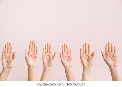 Women With Drawn Symbols Of Woman On Their Palms Against Color Background. Concept Of Feminism