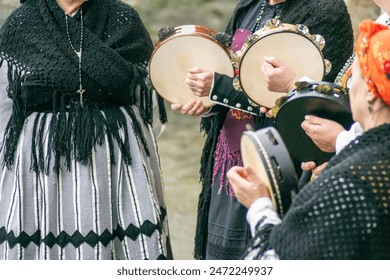 women dressed in traditional Galician costume playing tambourines at a popular festival, folk music - Powered by Shutterstock