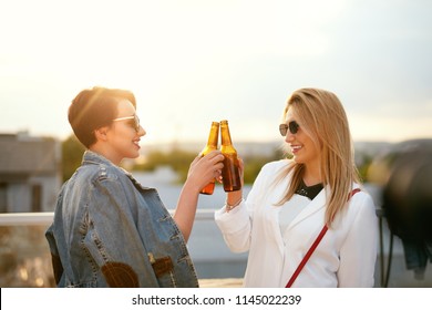 Women Drinking Beer From Bottles Outdoors