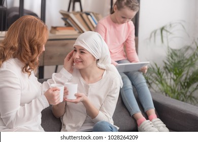 women drinking tea and child using digital tablet, cancer concept - Powered by Shutterstock