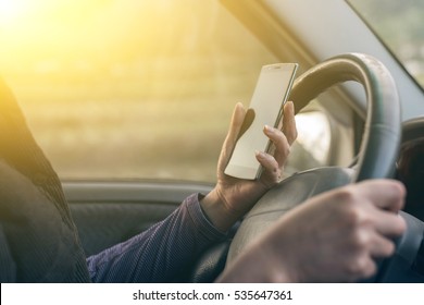 Women Driver With A Cell Phone In Hand While Driving