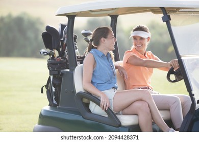 Women driving cart on golf course - Powered by Shutterstock