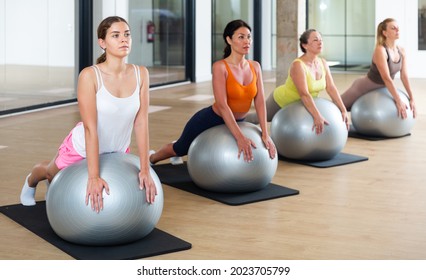 Women During Group Workout With Fitness Ball At Gym. Healthy Lifestyle Concept