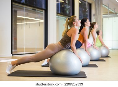 Women During Group Workout With Fitness Ball At Gym. Healthy Lifestyle Concept