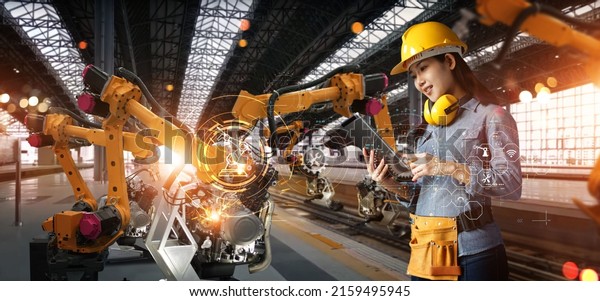 Women engineer check and control welding robotic\
automatic arms machine in intelligent factory automotive industrial\
with monitoring software connected to network. Digital\
manufacturing. Industry\
4.0