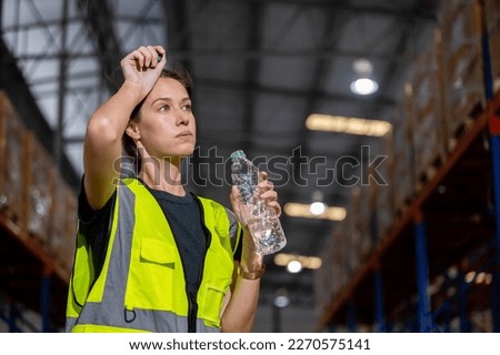 Women engineer drinking water from plastic bottle after working at factory during break. Drinking pure water refreshes body. Image female drinking water for advertise.