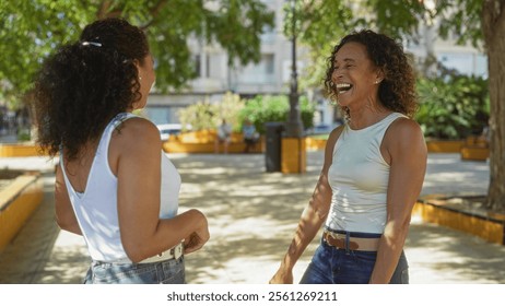 Women enjoying a conversation in a sunny urban park showcasing friendship and happiness, with vibrant greenery and city buildings in the background. - Powered by Shutterstock