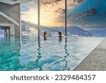 Women enjoying the panoramic view from the pool in the alps