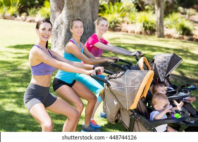 Women exercising with baby stroller in park