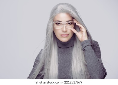 Women eyewear. Stylish silver hair woman in clear glasses staring at camera with confidence. successful business woman with long silver hair, wearing fashionable clear eyeglasses. - Shutterstock ID 2212517679