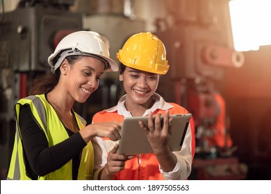 Women in factory engineer mix race working together using tablet happy smile