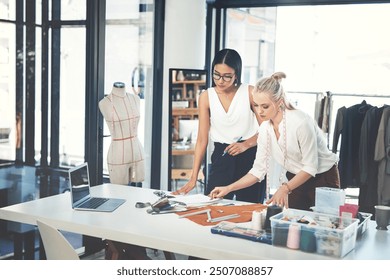 Women, fashion and designers with garment at workshop for material, design or teamwork at office. Young, female person or tailors working together on clothing line for style, size or production - Powered by Shutterstock