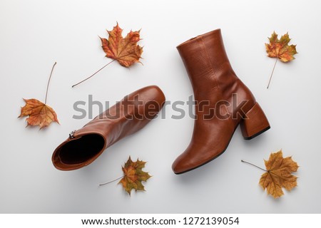 Women' fashionable brown leather ankle boots with heel on white background. Flat lay, top view.