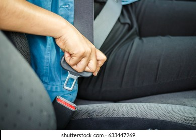 Women are fastening seat belt.