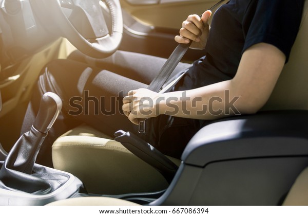 women fastening seat belt in\
car