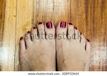 women feet after pedicure with red nails background