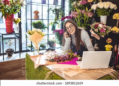 Women florist looking laptop got order at counter of her flower shop, occupation working concept. Smiling flower shop owner working on laptop computer. Woman standing at counter. - Powered by Shutterstock