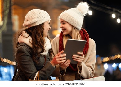 Women friends enjoy the night in shopping at Christmas. Sale, people digital tablet concept - Powered by Shutterstock