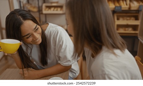 Women friends enjoying coffee together in a bakery, showing love and connection - Powered by Shutterstock