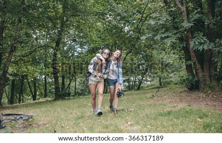 Women friends laughing while walking in forest