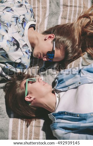 Similar – Two women with sunglasses smiling lying in blanket