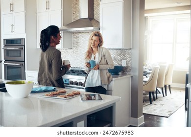 Women, friends and talking in kitchen with coffee, smile and listening to story with baking, cookies and diversity in home. People, drink and tea cup with conversation, cooking and biscuit in house - Powered by Shutterstock