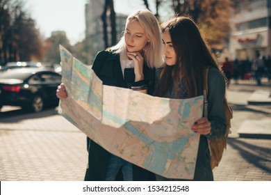 Women Friends Tourists Exploring European City While Holding Map