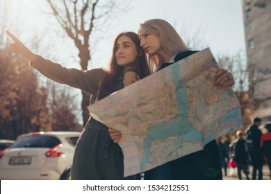 Women Friends Tourists Exploring European City While Holding Map