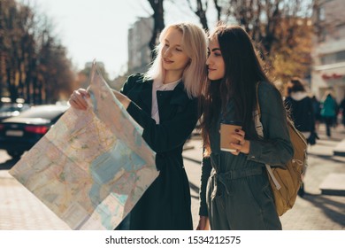 Women Friends Tourists Exploring European City While Holding Map