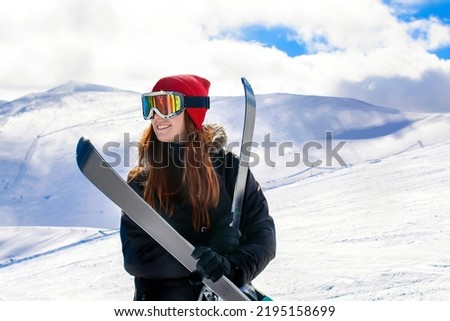 Women, girl in winter overalls,ski mask,glasses with skis,on snow hill looking at high Carpathian mountains at winter alpine ski resort holiday, outdoor nature landscape, Ukraine, Europe.aerial view.