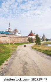 Women go down the dirt road from the Solovetsky Holy Transfiguration Monastery at summer