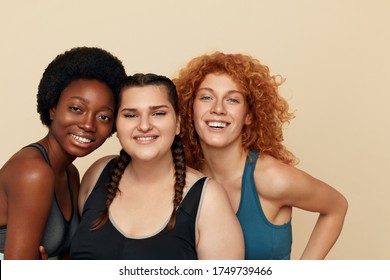 Women. Group Of Diversity Models Portrait. Smiling Multiethnic Female In Fitness Clothes Posing On Beige Background. Body Positive As Lifestyle. 