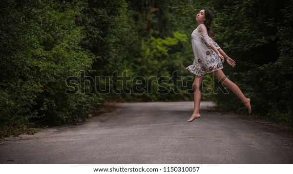women is hailing a car on a road. Thumbing a ride.\
Outdoors vacation. Asian