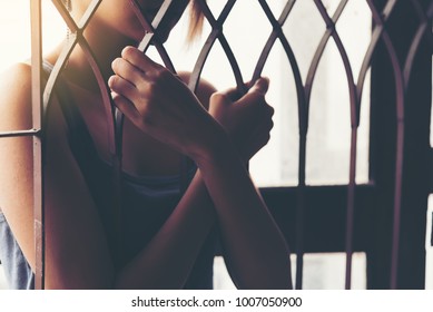 Women hand catching railling. Feeling no freedom. Women holding the cage imprisoned make no freedom or lack of freedom. Women hand holds railling sign as a detain in jail and loneliness.
