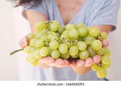 Women Hand Holding A Bunch Of Green Grapes