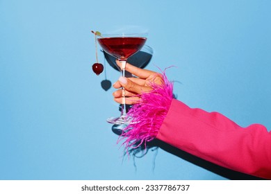 Women hand holding glass with drunk cherry cocktail over blue pop art background. Copy space for ad. Concept of party, relax, alcohol. - Powered by Shutterstock