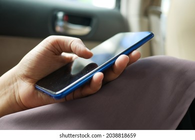  women hand holding smart phone in a car  - Shutterstock ID 2038818659