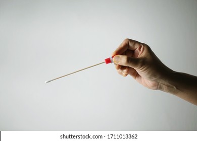 A women hand holding sterile swab kit for Covid-19 investigation. Photograph with white background and single lighting effects.