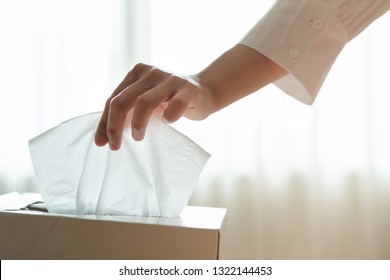 women hand picking napkin/tissue paper from the tissue box - Shutterstock ID 1322144453