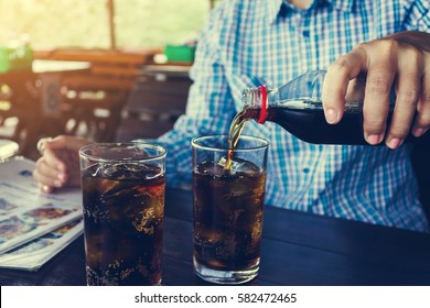 Women Hand Pour Or Fill Drink In Glass, Double Glass Of Soda On Wooden Table