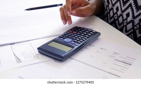 Women hand using a Scientific Calculator close up, with exam preparation papers on the table. School and university study, maths and physics concept. - Shutterstock ID 1275279403