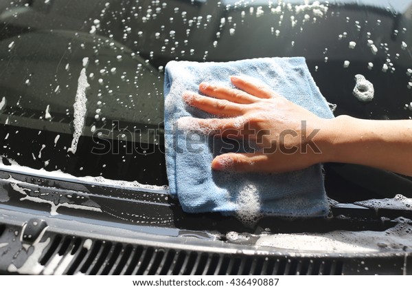Women Hand in Wash a car with\
Microfiber Cloth for design Concept Cleaning\
vehicle.\
