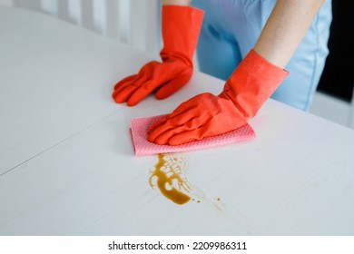 Women Hands Cleaning Tea Stain Or Spilled Coffee On A White Table With A Yellow Dishcloth Closeup