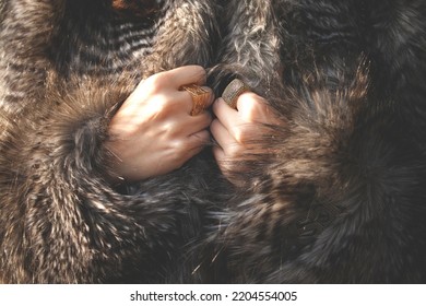 Women Hands Grasping Faux Fur Coat With Golden Rings