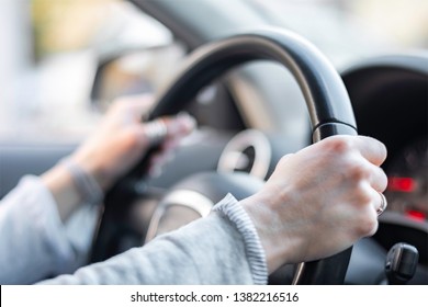 Women hands holding car steering wheel - Female hand close up shallow dof depth of field driving car - Hands on steering wheel in traffic