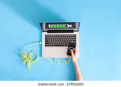 Women Hands Holding Phone With Low Charged Battery Screen Charging From Laptop