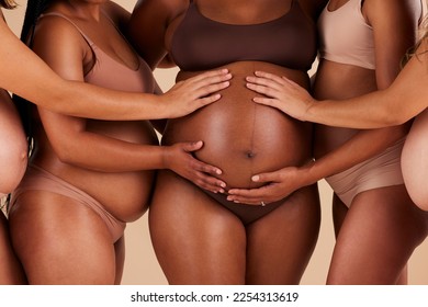 Women, hands or touching pregnancy stomach of black woman on studio background in growth support, love or community. Zoom, body or friends in pregnant underwear and belly feeling for baby health kick