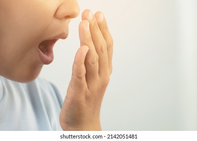 Women have bad breath caused by swollen gums. - Shutterstock ID 2142051481